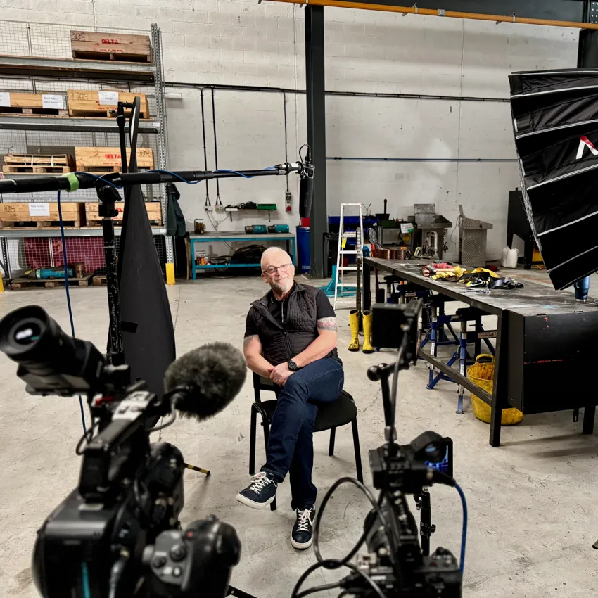 Camera and lighting setup for a corporate interview in a workshop