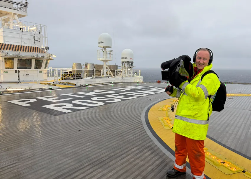 Elliot Hornell with a shoulder-mounted camera on an offshore helideck